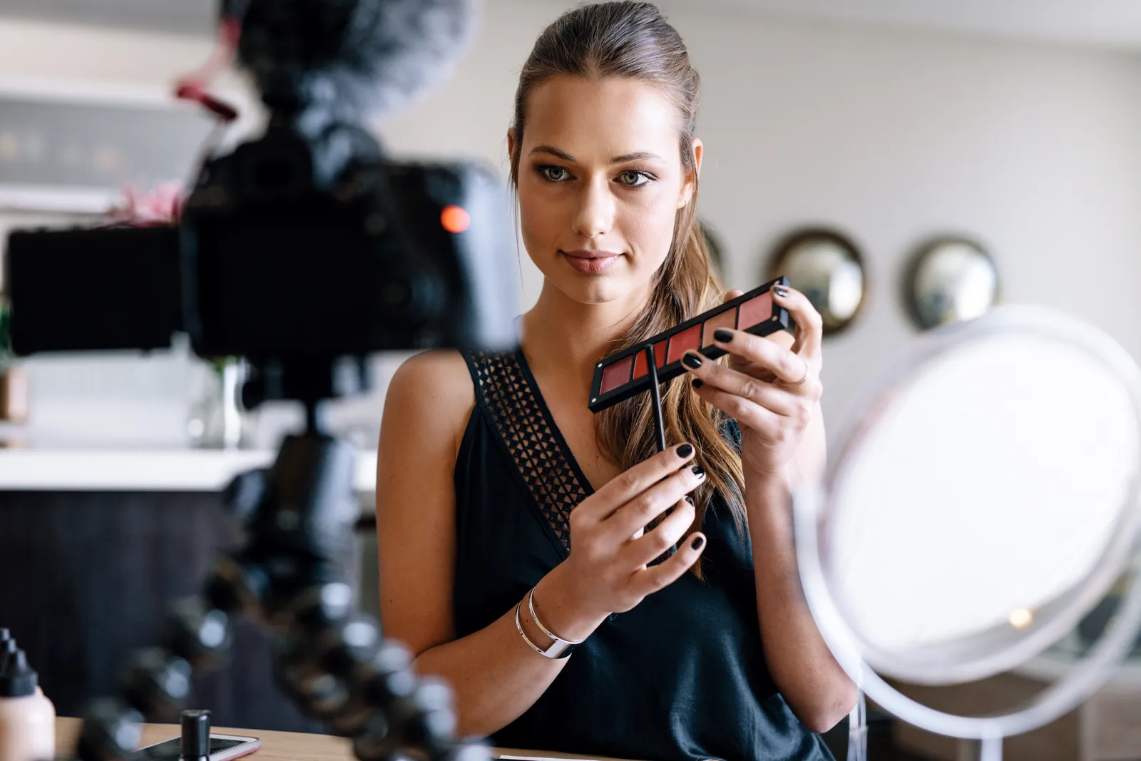 A creator filming herself with a phone on a ring light