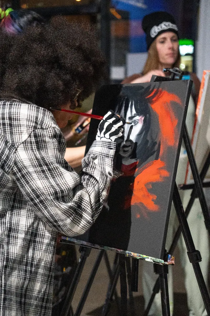 An artist painting a portrait live at Founders Alley
