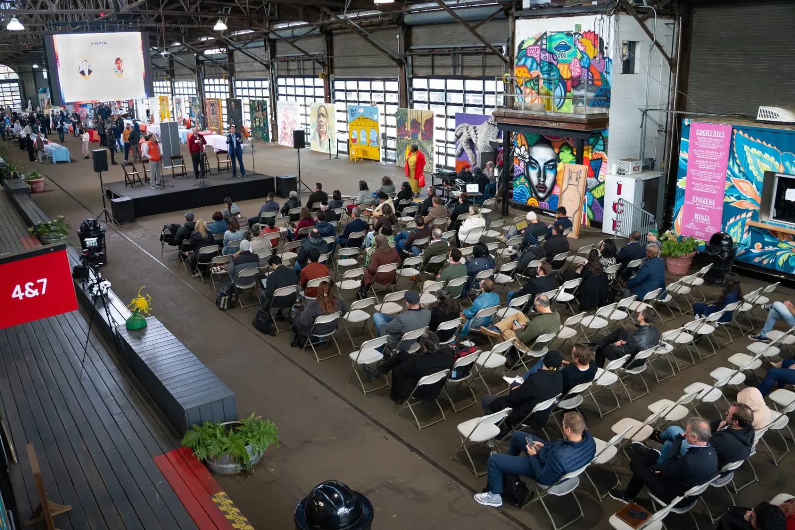 A full audience watching the main stage program inside Cherry Street Pier